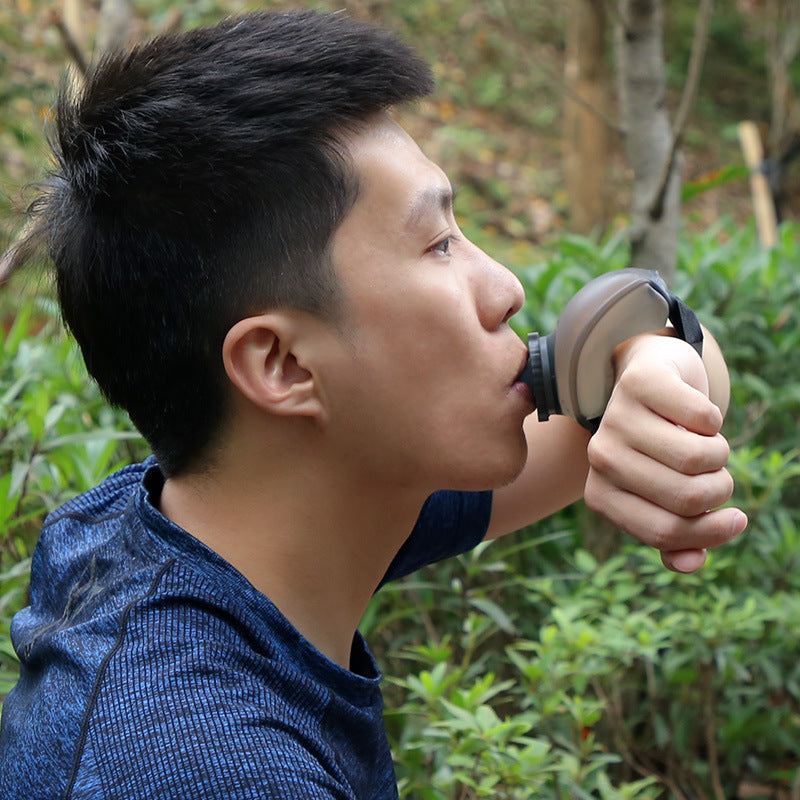 VeyaSports runner drinking from a portable 200ml silicone wrist water bottle while outdoors